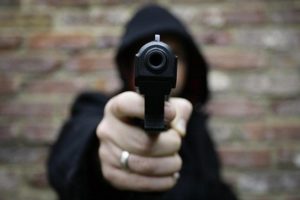 A hoodie brandishes a replica heckler and koch handgun August 23